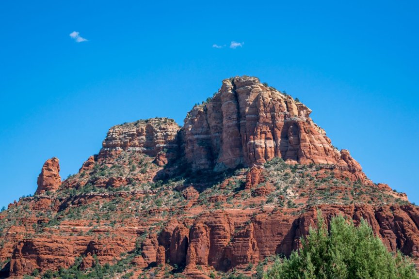 Sedona's iconic red rock formation against a vibrant blue sky, showcasing natural beauty.
