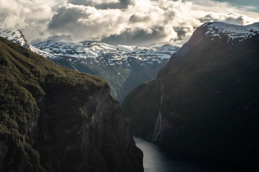 Spectacular view of Geirangerfjord in Norway, featuring majestic cliffs and snowy peaks.
