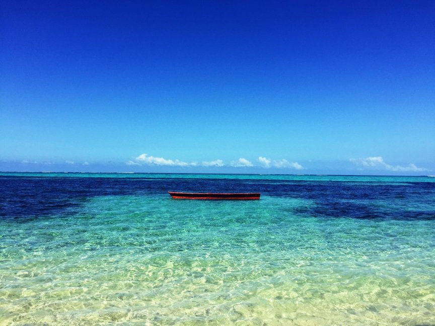 A serene view of a boat floating on clear turquoise waters near Navosa, Fiji.