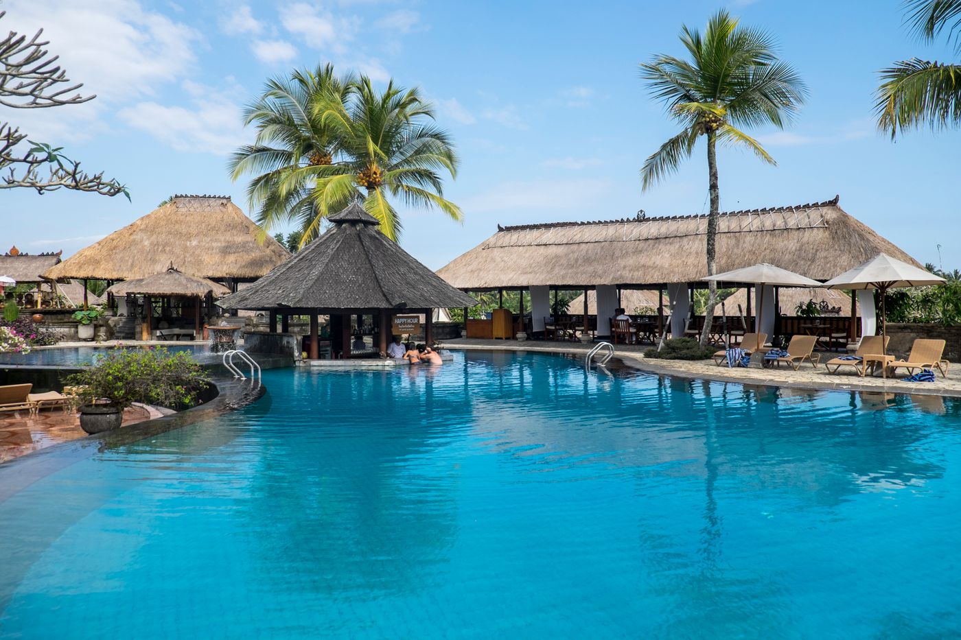 A family enjoying a resort pool on a sunny day