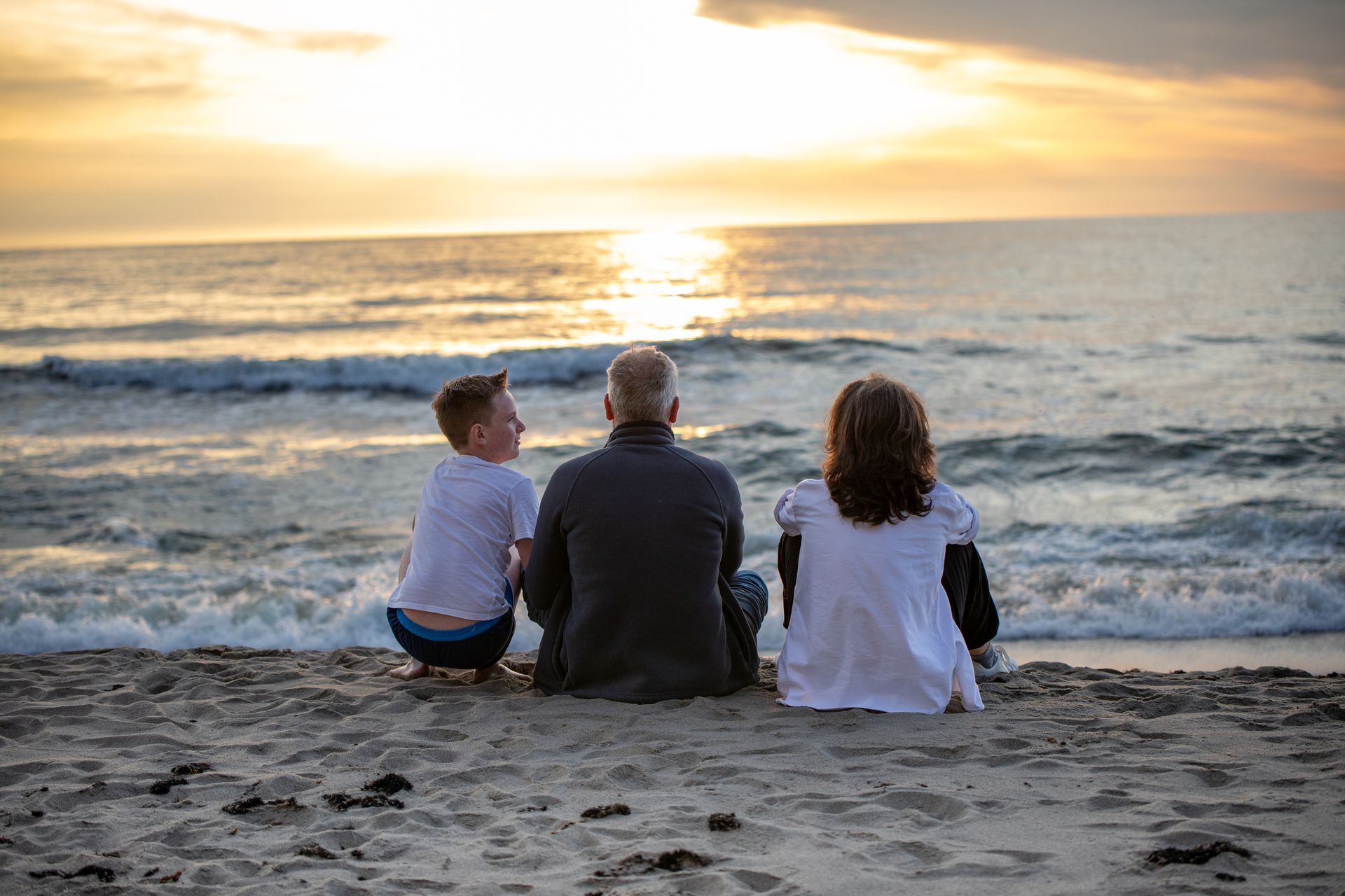 A family walking along the beach together at golden hour