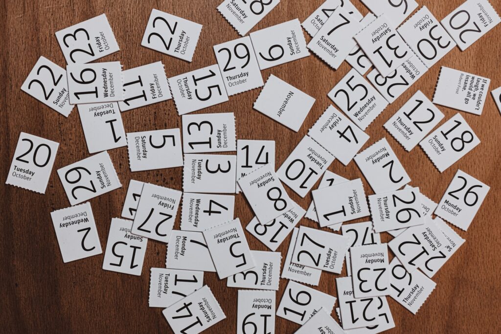 a calendar where each day's square is cut out and strewn across a table to signify the travel tip to avoid overplanning