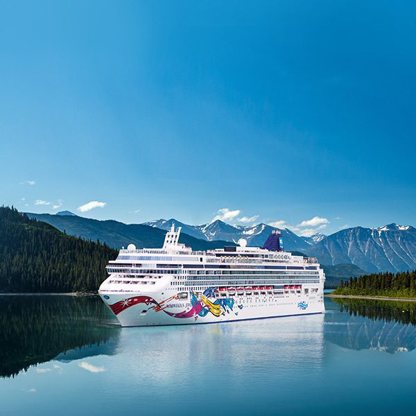 Norwegian Cruise Line ship sailing through Alaskan waters, offering breathtaking views and luxurious amenities.