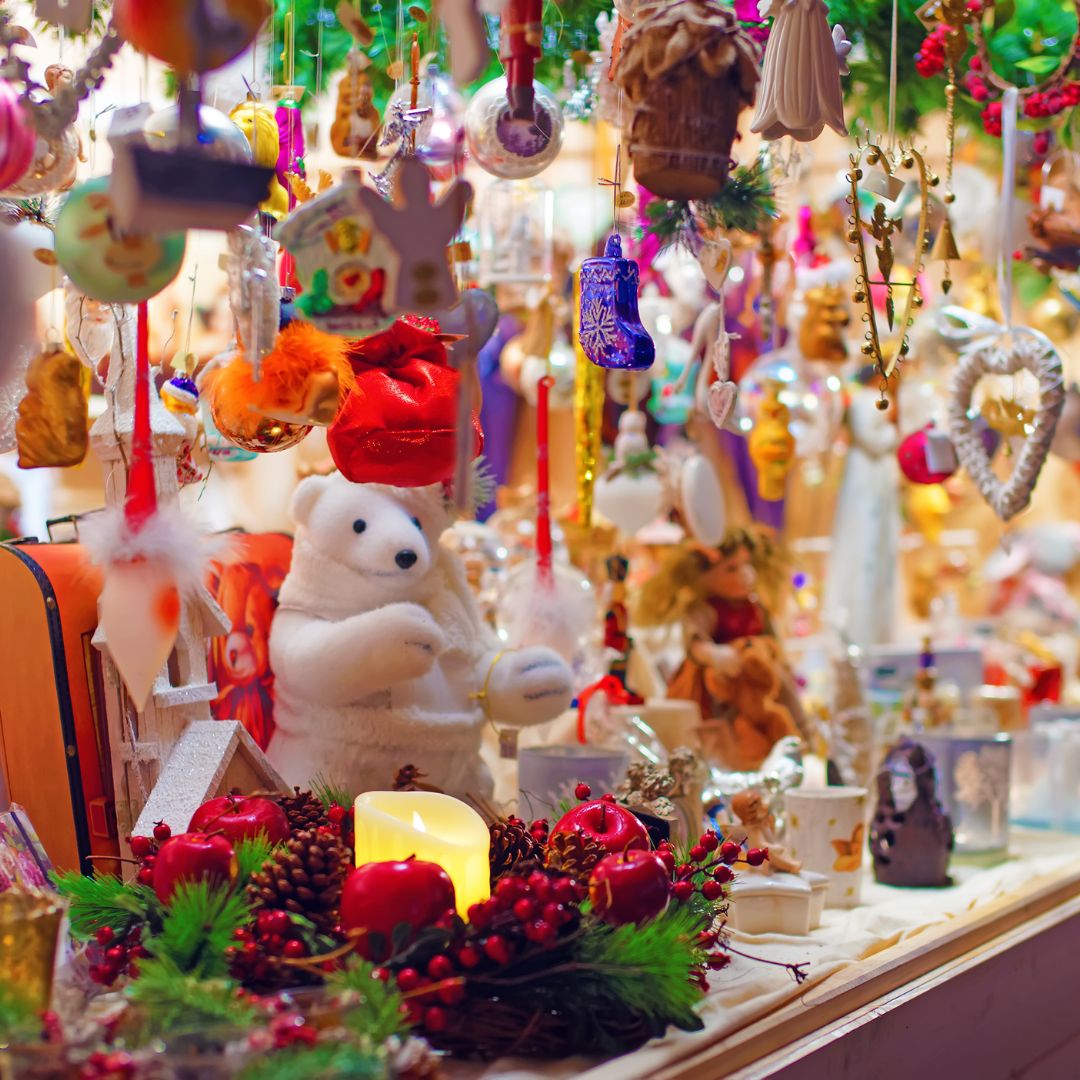 Colorful Christmas market stall with ornaments, candles, and holiday decorations.